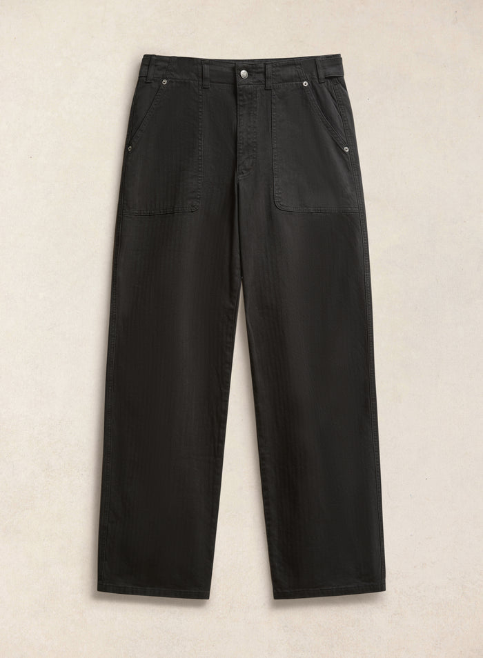 The black Percival Lungo Carpenter Trousers in cotton herringbone, featuring utility-inspired front patch pockets.