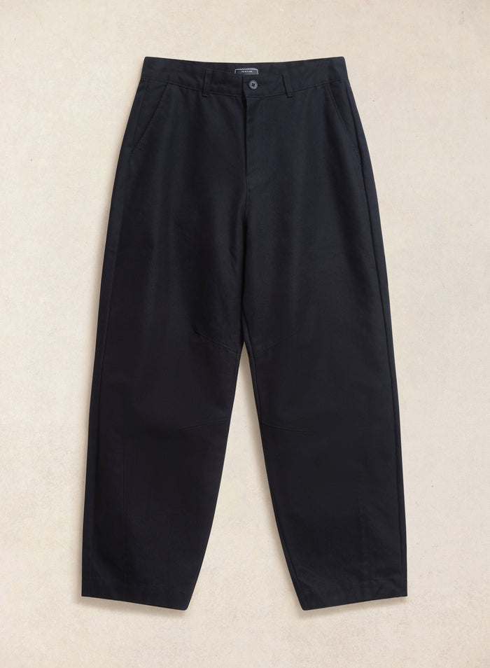 The black Percival Milo relaxed barrel leg trousers laid flat, showing the waistband, panel detailing, and side pockets.