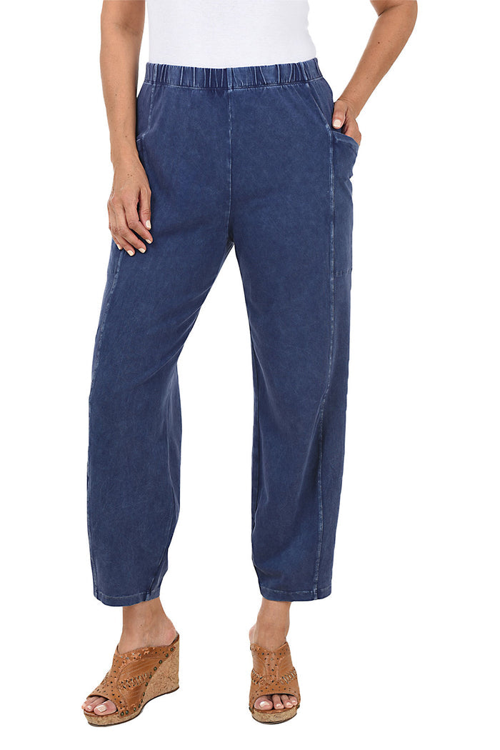A front shot of a model wearing a denim mineral wash pull-on ankle pants with an elasticized waistband, dual side pockets, and tapered leg design.