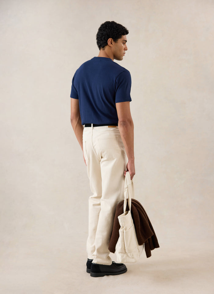 Model wearing Percival's navy Plain Regular Fit T-shirt with cream jeans and black loafers.