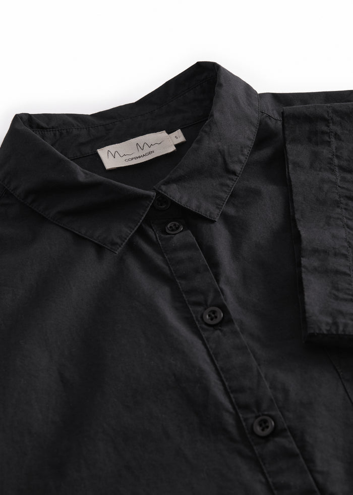 Short black shirt for women with a loose fit, classic collar.