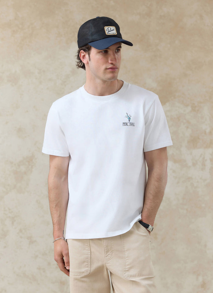 White organic cotton Percival Walker T-shirt with a small chest graphic, styled on a model with a mesh cap.