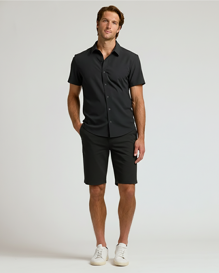 Man wearing The Timeless 9 Chino Shorts, black shirt, white sneakers.