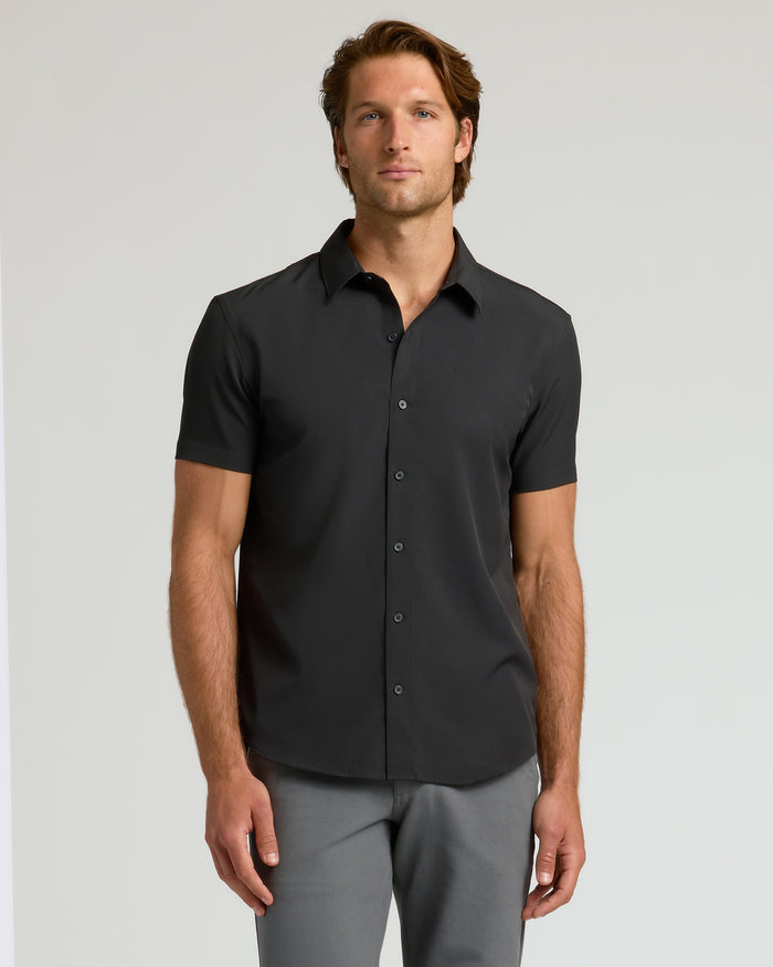 Man wearing All Black Short Sleeve Performance Dress Shirt, relaxed posture.