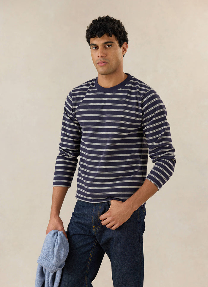 A model wears the Percival navy stripe Arlo long-sleeve Breton T-shirt in a studio setting.