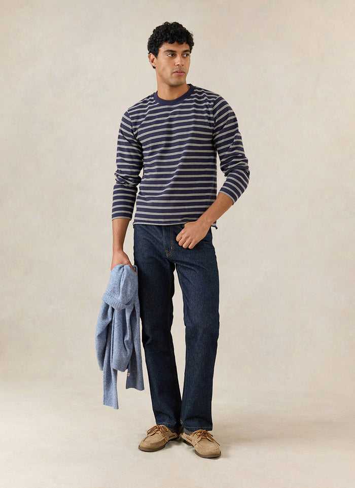 A model wears the Percival navy stripe Arlo long sleeve Breton T-shirt with dark trousers and shoes.