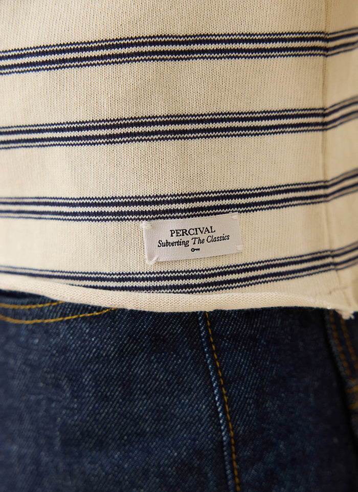 A close-up of the Arlo white stripe Breton t-shirt from Percival, showing the branded label detail on the hem.