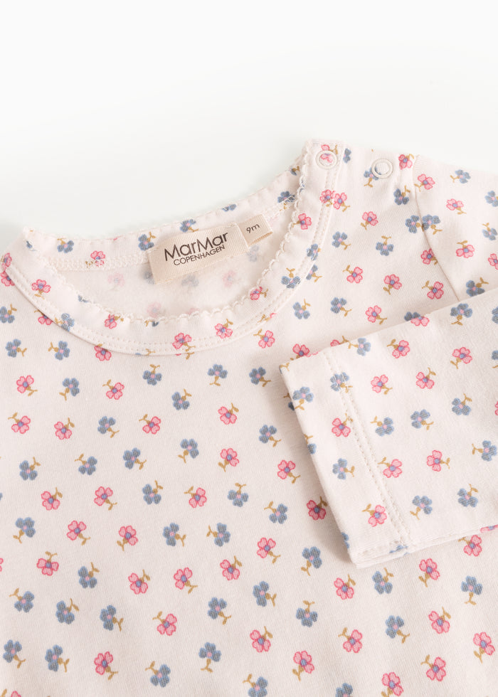 Detalje af lys bodystocking med blomsterprint og rund halsudskæring