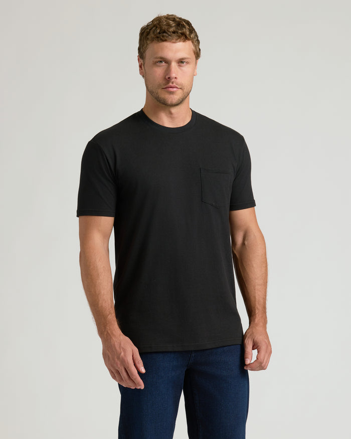 Man wearing Black Pocket Crew Tee with dark jeans, standing relaxed.
