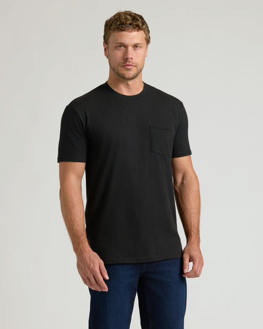 Man wearing Black Pocket Crew Tee with dark jeans, standing relaxed.
