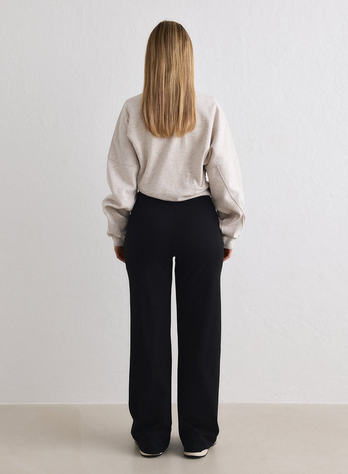 Back view of a model wearing Black Sense Petite Pants and a beige top [M-170cm]