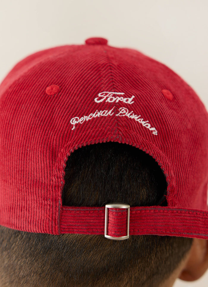 Red corduroy Ford x Percival trucker cap shown from the back with white cursive embroidery and an adjustable metal buckle.