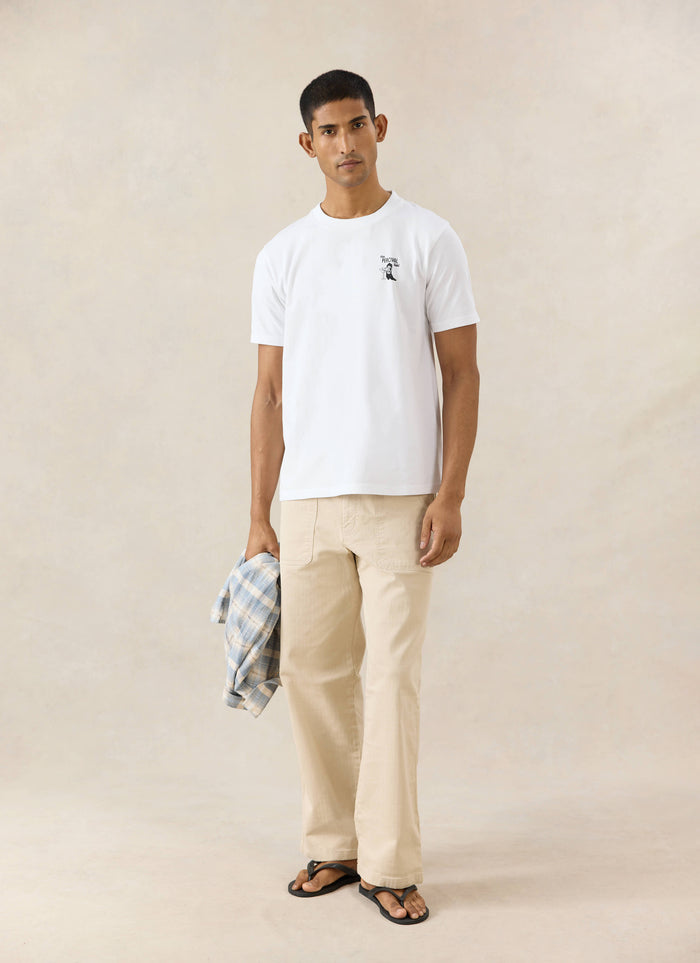 White organic cotton Percival Cowboy Boot T-shirt with a western graphic, styled with tan Lucas carpenter trousers.
