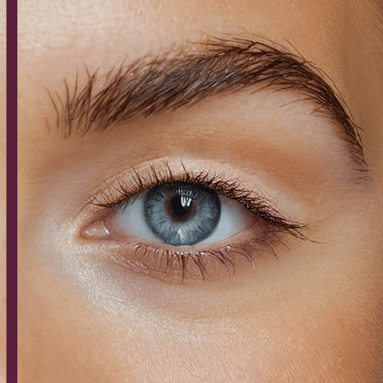 Close-up of a blue eye with natural eyelashes and well-groomed eyebrow, highlighting the effect of Curling TUBING™ Primer | Blinc for enhanced lash appearance.