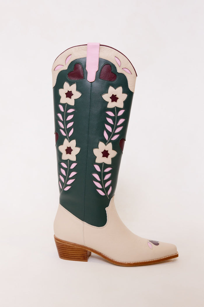 The Dakota Boot in Green & Cream by Ivy City Co is a tall leather cowboy boot with a tan foot, green shaft, classic wooden heel, and beautifully detailed pink, white, and burgundy floral embroidery along the side—offering a perfect blend of timeless Western style and vibrant accents.