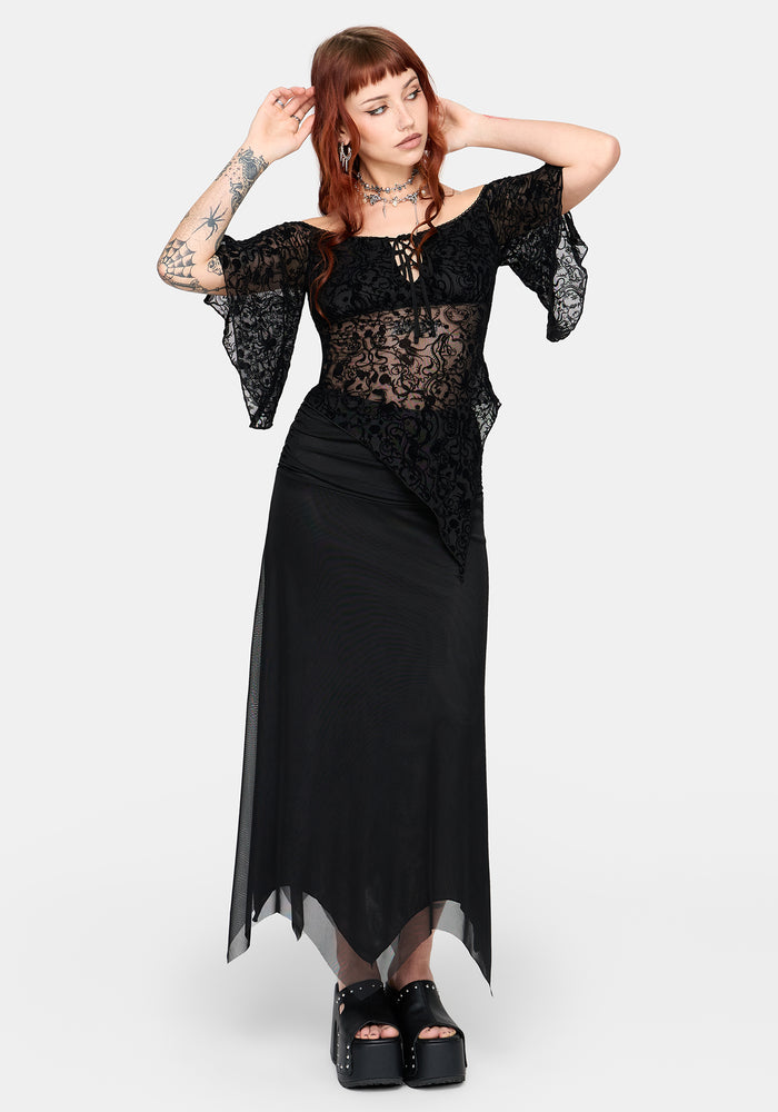 Woman wearing a black lace top and black skirt on a white background