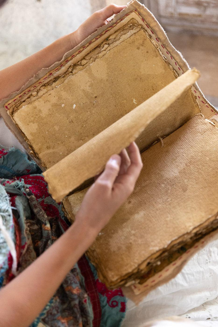 Hand holding vintage handmade book, rustic artisan pages, Magnolia Pearl whimsical style
