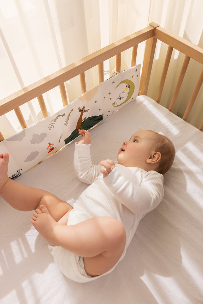 Foldebar stofbog med Moomin-illustreret stribe, brugt i tremmeseng ved baby