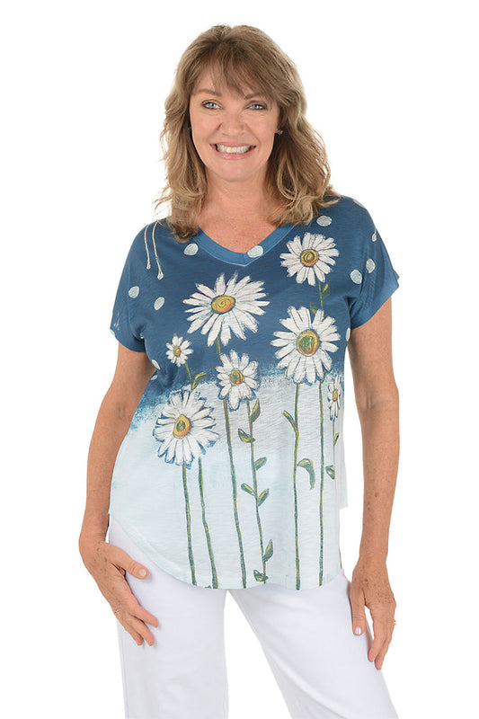 A woman wearing a navy blue and white short sleeve v-neck shirt with a daisy flower design.