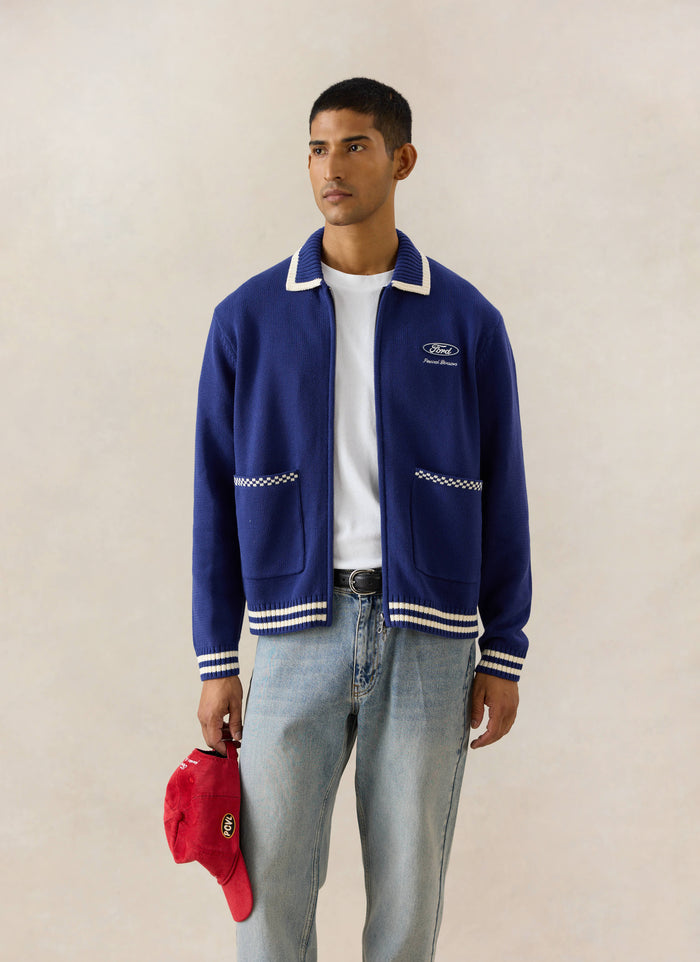 Blue Percival x Ford Gardner knitted zip cardigan with white trim, styled with light wash heritage denim jeans.