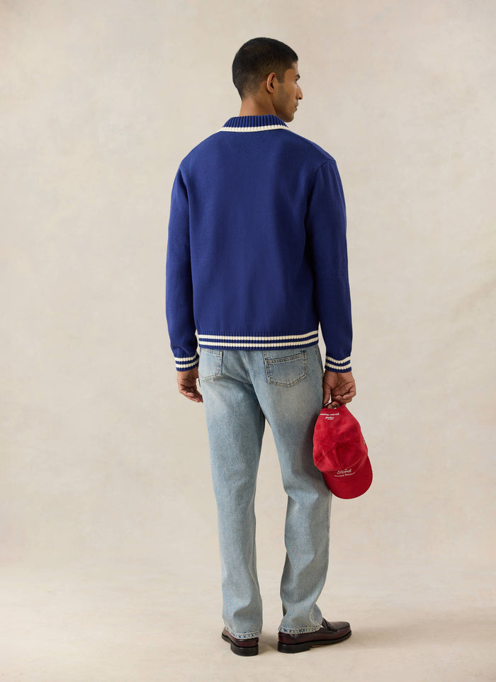 Rear view of the cobalt blue Ford x Percival Gardner Knitted Cardigan, styled with light wash straight-leg jeans.
