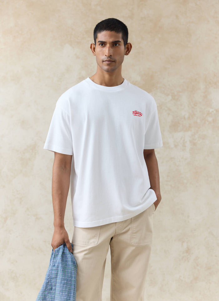 A model wearing the white Percival Gordon oversized organic cotton t-shirt with a red Motel Percival chest logo.