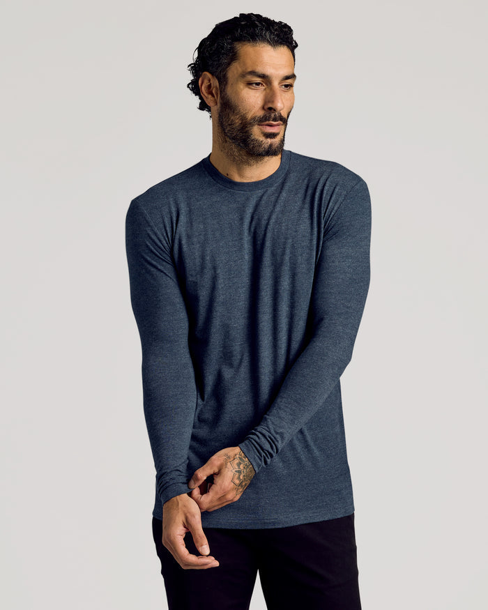 Man wearing Heather Navy Tall Long Sleeve T-Shirt adjusting sleeve.