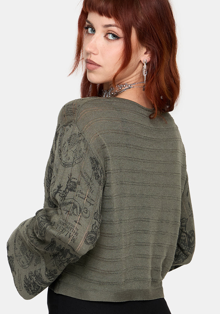 Woman wearing a green sweater with intricate patterns on a white background
