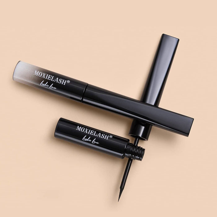 Two sleek black eyeliner tubes with brush applicator, one closed and one open, displayed on a beige background showcasing Lashies™ - Liner | Moxielash.