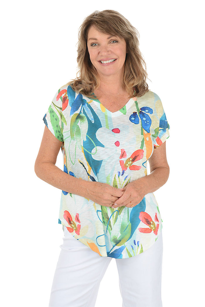Woman wearing a white short sleeve v-neck shirt with a floral design.