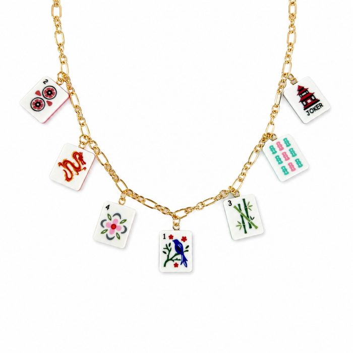 Gold necklace with playing card charm charms on a white background