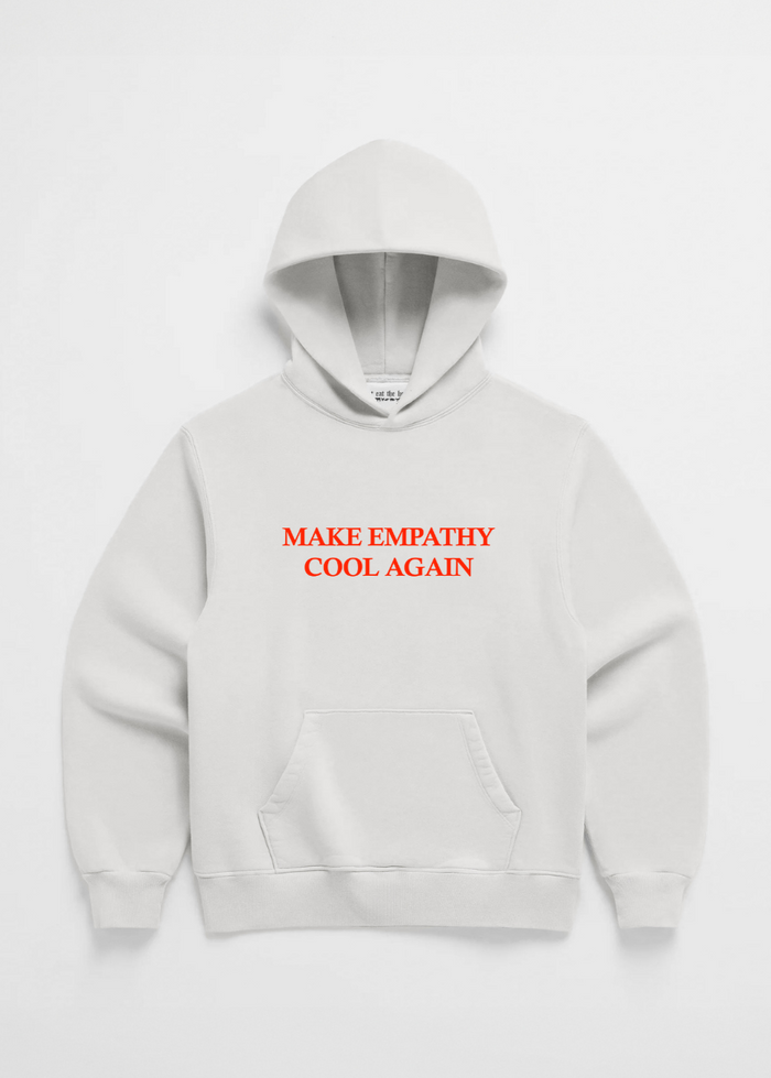 A pink hoodie with the text 'MAKE EMPATHY COOL AGAIN' printed in red on the front center chest area.