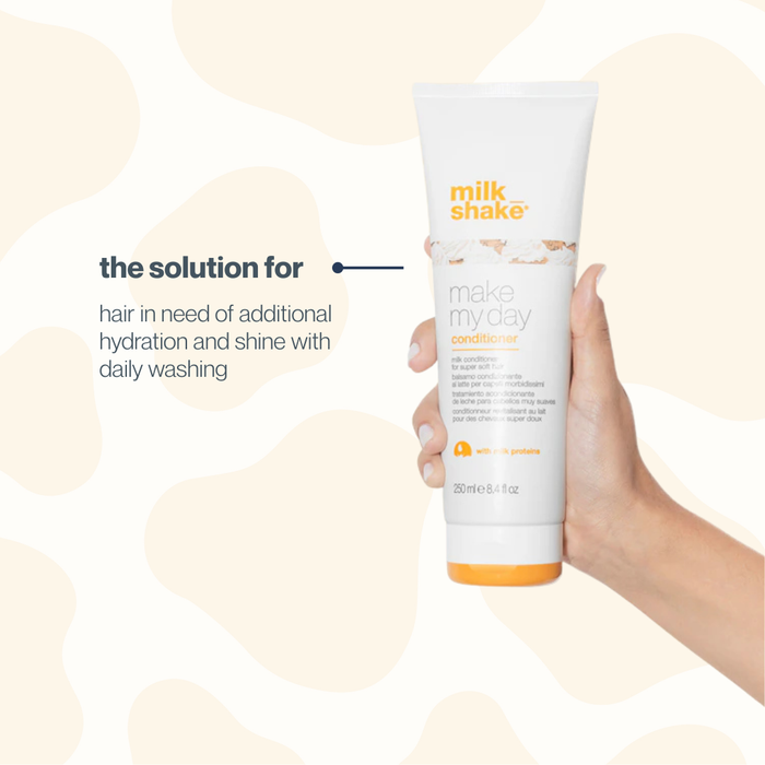 Hand holding a bottle of 'milk_shake' conditioner with text on a beige background