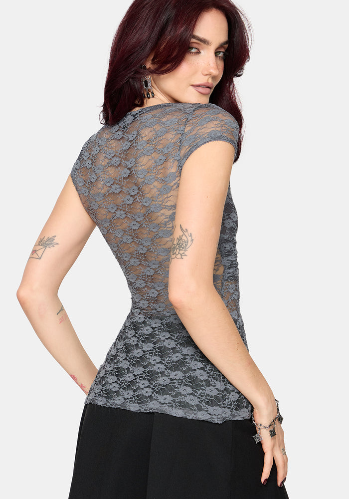 Woman wearing a gray lace top against a white background