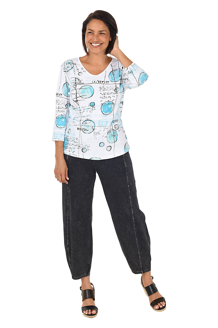 A full length shot of a model wearing a black mineral wash pull-on ankle pants with an elasticized waistband, dual side pockets, and tapered leg design.