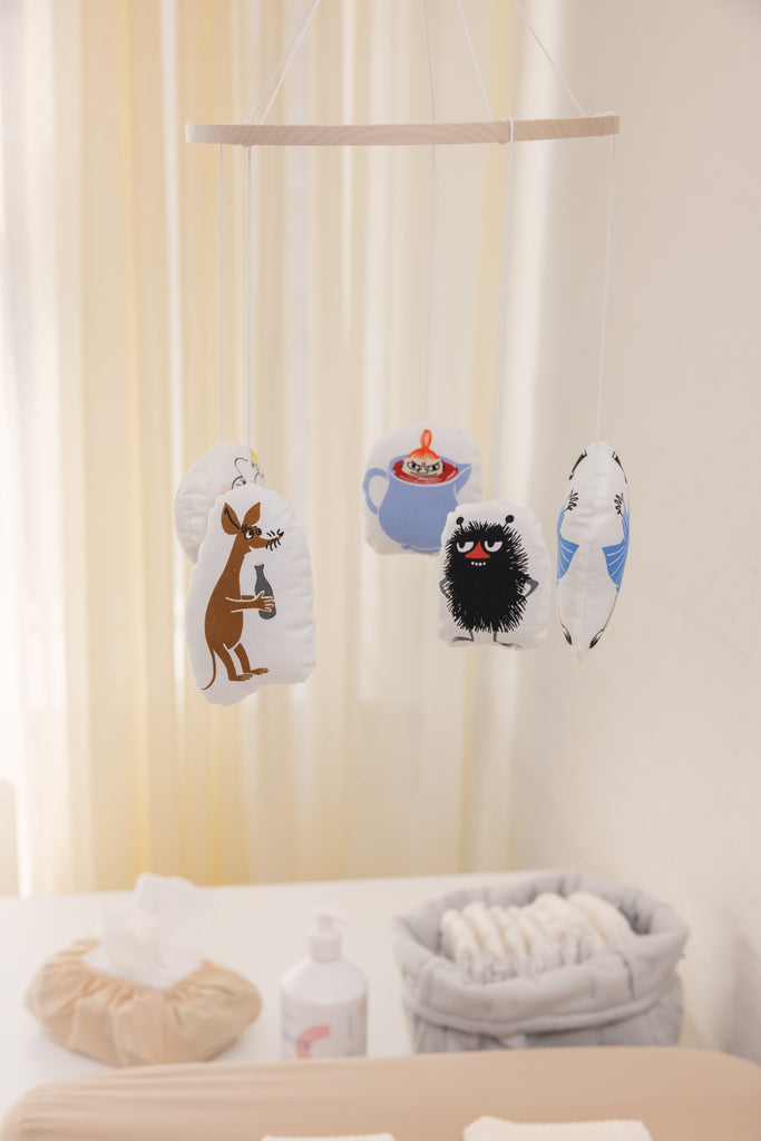 Babymobil til baby med flere Moomin-figurer, ophængt i små stofposer.