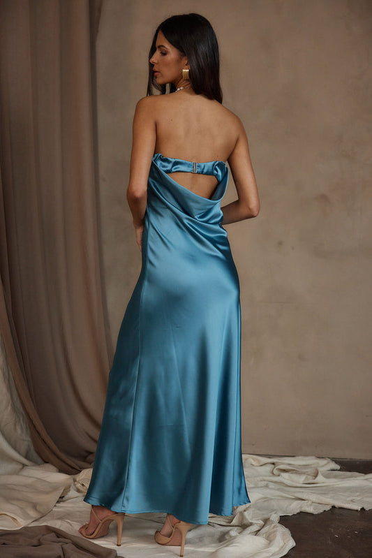 Back view of blue satin strapless maxi dress with cutout detail and nude heels.