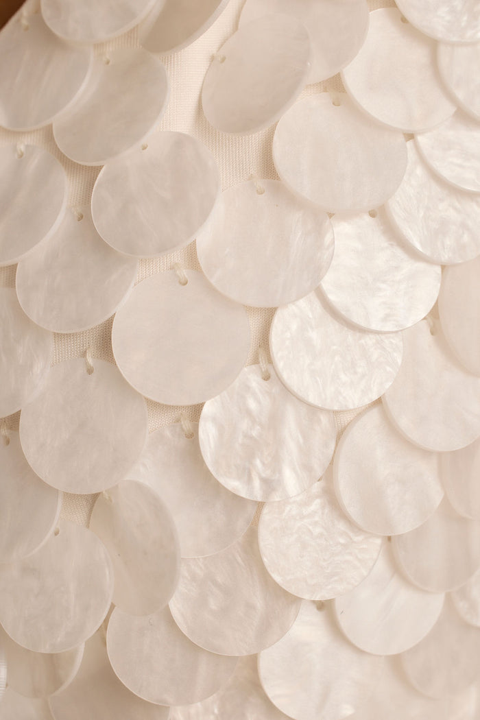 Close-up of overlapping pearl white payette discs on the Oceana top's mesh base.