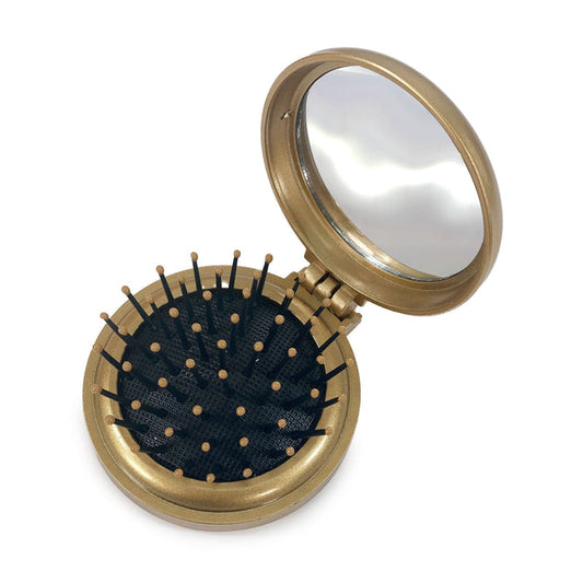 The Perfect Locks Compact Travel Brush has a gold case, pop-out brush for Remy hair extensions, mirror, and black bristles tipped in gold.