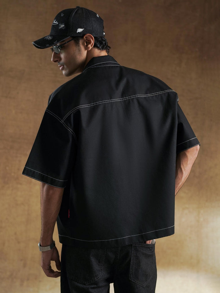 Black boxy shirt worn open over a white tee - GROOVY Pakistan