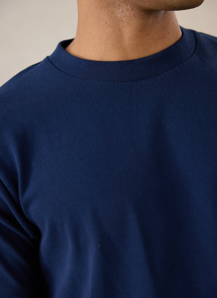 Close-up of a model wearing Percival's navy Plain Regular Fit T-Shirt, showing the ribbed crew neck.