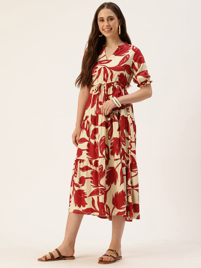 Woman in a red and white floral dress holding a brown handbag, standing next to a small wooden table with flowers on a beige background. Red Floral Printed Puff Sleeves Midi Dress, midi dress, dress, women’s western wear, party wear dress, casual wear dress