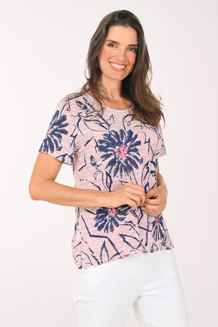 Woman wearing a pink and blue daisy print tee.