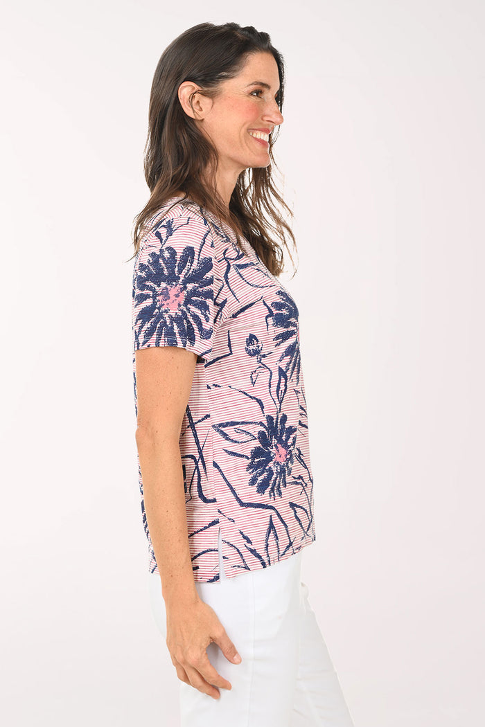 Woman wearing a pink and blue daisy print tee.