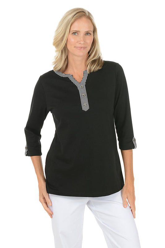 Woman wearing a black long-sleeve top with a white background.