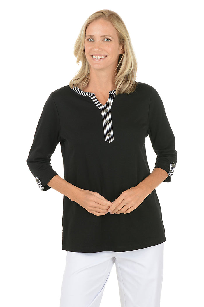 Woman wearing a black long-sleeve top with a white background. Second front shot.