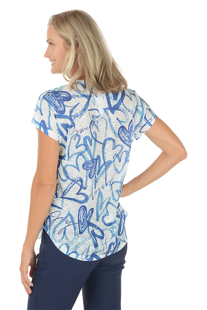 A woman wearing a blue and white short sleeve v-neck shirt with a heart design. Back shot.