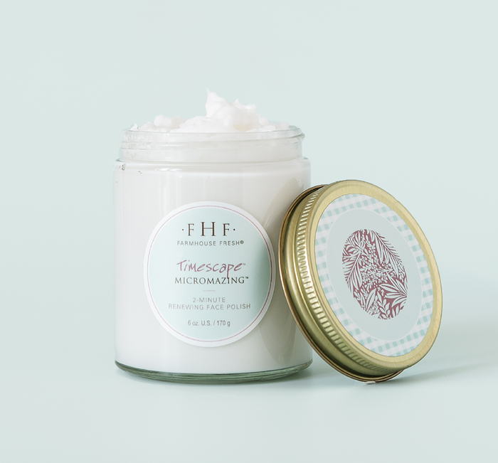 Open glass jar of Timescape™ Micromazing™ 2-Minute Renewing Face Polish | Farmhouse Fresh showing creamy white skincare product with gold metal lid beside it on a light background.