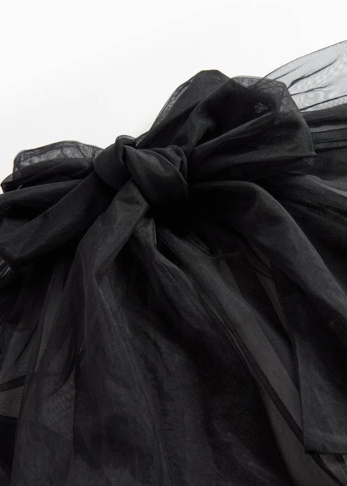 Detail of black tulle blouse with bow