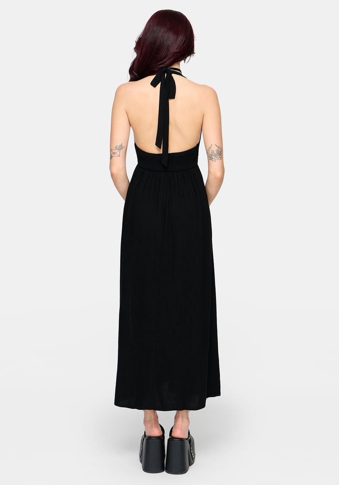 Black halter neck dress with open back worn by a woman on a white background